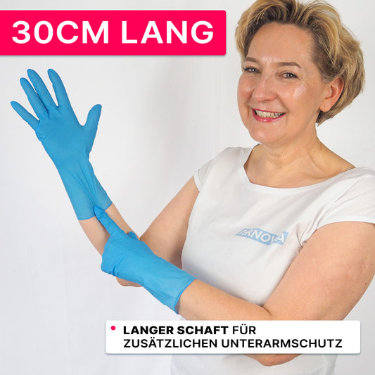 Eine Person in einem weißen Hemd und blauen Nitrilhandschuhen der ARNOWA GmbH lächelt und zeigt auf die 30 cm lange Stulpe. Auf einem rosafarbenen Banner steht "30CM LANG" und weist darauf hin, dass die ARNOMED NITRIL BLUE XTRA LONG Handschuhe einen zusätzlichen Schutz für den Unterarm bieten.