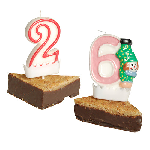 Eine rot-weiße "2" und eine rosa-weiße "6" Zahlenkerze mit Clown werden auf Brownie-Keile gestellt, jeweils mit dem PAPSTAR Halter für Zahlenkerzen (weiß, 3,8x4,9 cm) als stabile, dekorative Geburtstagskerzenhalter.