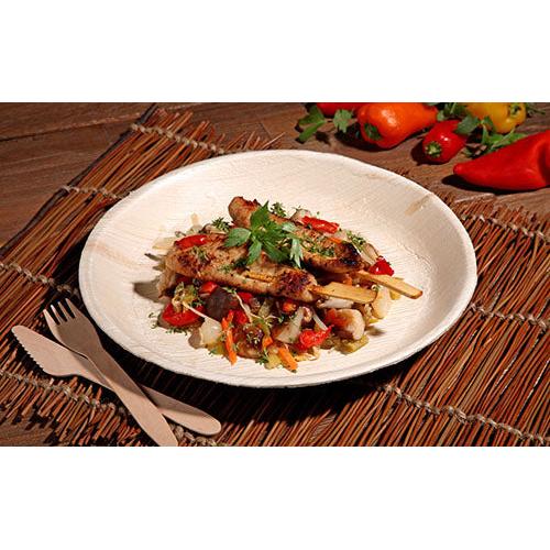 Gegrillte Hähnchenspieße mit farbenfroher Gemüsepfanne werden auf einem PAPSTAR 6 Teller, Palmblatt „pure“ rund von der PAPSTAR GmbH serviert – umweltfreundliches Geschirr, stilvoll präsentiert auf einer gewebten Unterlage mit Holzbesteck und frischen Paprikaschoten im Blick.