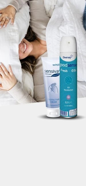 Hautpflegeprodukte mit schülke sensiva Protective Cream und Diversey Good Sense Fresh Duftspray vor entspanntem Hintergrund im Bett.