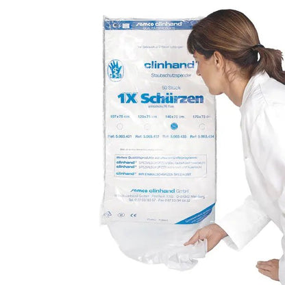 Une femme en blouse blanche sort un tablier jetable Clinhand pour femmes, 120 cm, d'un paquet Altruan portant l'inscription "50 pièces" - tabliers jetables avec des informations produit en bleu et noir sur le devant.