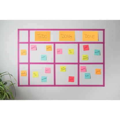 Un tableau Kanban monté au mur affiche des Post-it® Super Sticky Notes colorés de 3M Deutschland GmbH (76x127mm, 90 feuilles, 100% PEFC), étiquetés avec des tâches et des noms dans les colonnes "À faire", "En cours" et "Terminé". Dans le coin inférieur gauche apparaît une plante verte.