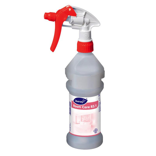Eine klare leere Sprühflasche mit rotem Auslöser und Verschluss von Diversey Deutschland GmbH & Co. OHG mit der Aufschrift „Room Care R5.1 Plus Sprühflasche, leer“, mit Produkt- und Reinigungsmittelinformationen und einem Raumbild im Hintergrund.