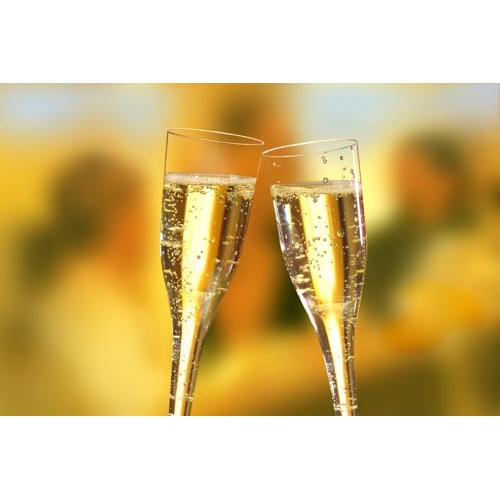 Deux verres à pied Starpak 50 (parties supérieures) pour champagne, PS 0,1 l transparents, sont levés pour un toast, mettant en valeur leur design clair avec des bulles vives devant un arrière-plan doucement flou et chaleureusement éclairé.