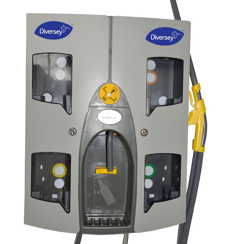 La station de dosage Quattro Select Uni AirGap de Diversey Deutschland GmbH & Co. OHG est un appareil mural gris pour jusqu'à 4 produits, avec quatre compartiments visibles, des plaques transparentes, des tuyaux fixés, un design compact, un bouton rotatif et un levier.