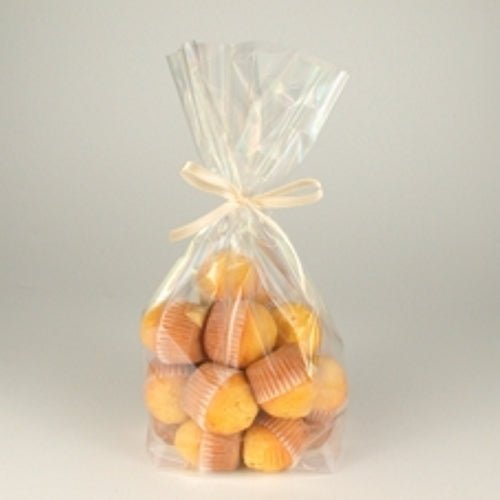 Les sacs à fond Starpak 10 en PP transparent contiennent de petits muffins jaunes dans des caissettes en papier brun, sont fermés par un ruban clair et disposés sur un fond simple.