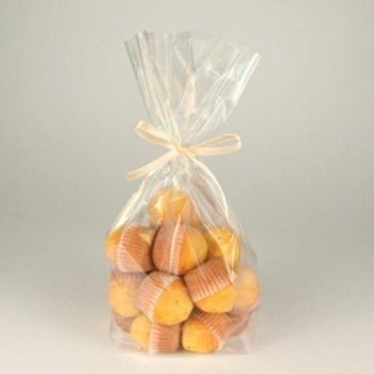 Les sacs à fond Starpak 10 en PP transparent contiennent de petits muffins jaunes dans des caissettes en papier brun, sont fermés par un ruban clair et disposés sur un fond simple.