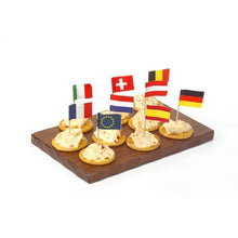 Un plateau en bois contient sept crackers, chacun avec une tartinade et surmonté d'un PAPSTAR pic décoratif 8 cm "Nations" (différents pays & UE). Parfait comme décoration de table pour fêtes et événements. Marque : PAPSTAR GmbH.