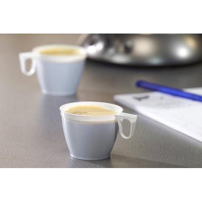 Deux petites tasses à café Starpak (PS, 0,18l, Ø7,8cm, blanc) d'un ensemble de 10 sont remplies de café sur un fond gris, à l'arrière-plan, on peut voir un stylo bleu et une feuille de papier blanche floue.