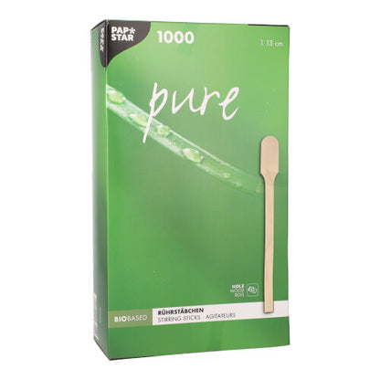 Une boîte « pure » verte PAPSTAR de PAPSTAR GmbH avec 1000 agitateurs sans éclats, naturellement légers de 13 cm en bois, est munie d'une photo d'un bâtonnet individuel et indique que le produit est biobasé et fabriqué en bois.
