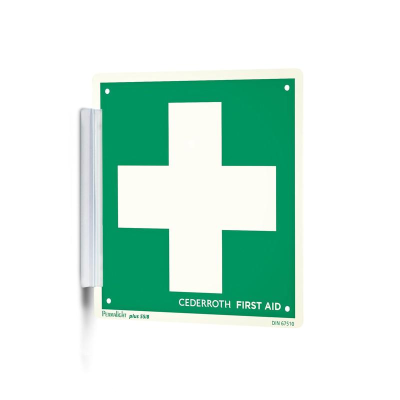 Un "Clip signer | Paquet (1 pièce)" vert-blanc de Orkla Wound Care AB avec une grande croix blanche et l'inscription "Cederroth First Aid" est fixé au mur comme un tampon de signature avec un support métallique et est ainsi bien visible sur le lieu de travail.