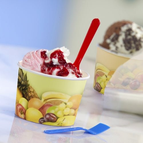 Un gobelet à glace rose et blanc avec une sauce rouge est servi dans un gobelet à glace Starpak 50 en carton rond avec des motifs de fruits. Une cuillère rouge est dans le gobelet, une bleue est à côté, et un autre gobelet Starpak est visible en arrière-plan.