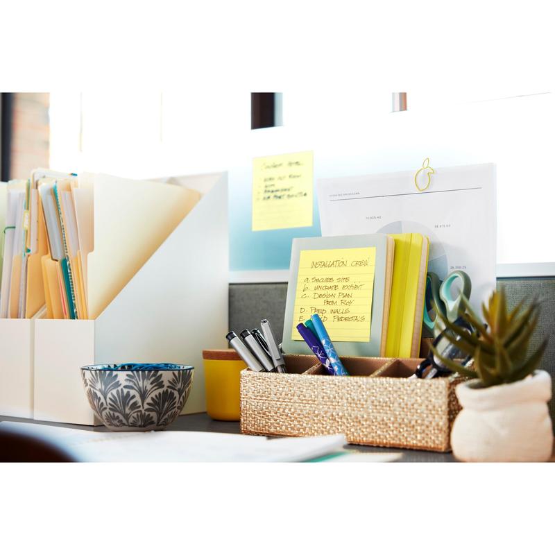 Un bureau bien rangé avec des classeurs, des documents, des stylos dans un récipient tressé, un plat décoratif, une petite plante et des Post-it® Notes de 3M Deutschland GmbH grand format (Jaune, 101x152 mm), l'un avec l'inscription "Installation Crew", à une fenêtre ensoleillée.