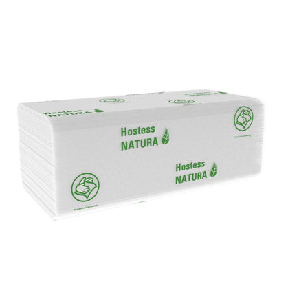 Une pile de serviettes blanches pliées Hostess™ NATURA™ C-Falz de Kimberly-Clark GmbH avec graphique de feuille verte, symbole du pouce levé, texte "Made in Germany" et branding écologique. 20 x 140 feuilles par carton.