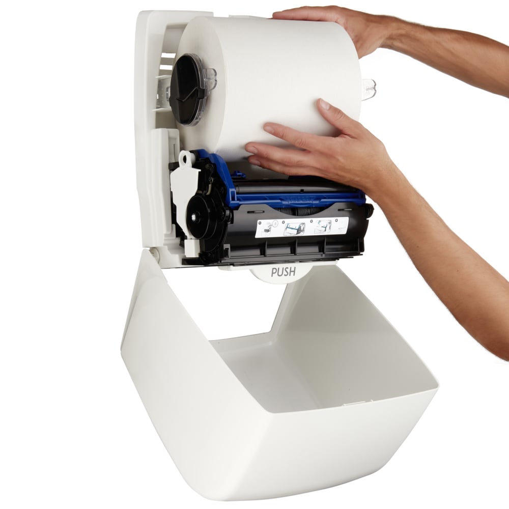 Une personne installe un grand rouleau de serviettes en papier dans le distributeur de serviettes en rouleau Aquarius™ - Blanc de Kimberly-Clark GmbH avec mécanisme visible - idéal pour les espaces publics exigeant une hygiène stricte.