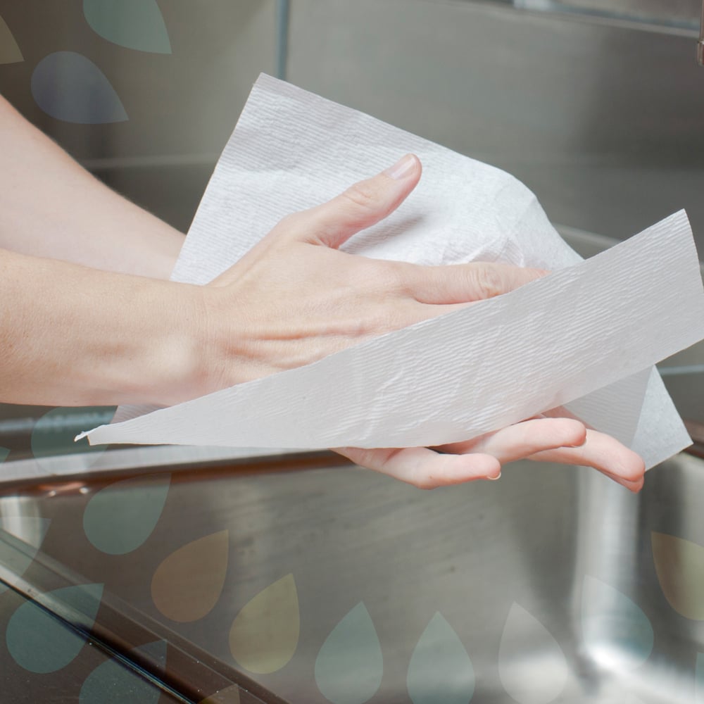 Une personne sèche ses mains avec des serviettes Kleenex® Ultra™ (Interfold, Blanc, Grand, 30 x 94 feuilles) de Kimberly-Clark GmbH au-dessus d'un évier en acier inoxydable.