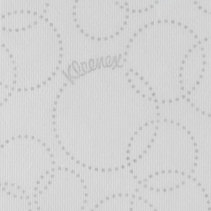 Un gros plan d'une serviette en papier Kleenex® Ultra™ MultiFold blanche de Kimberly-Clark GmbH montre un motif circulaire gris clair à pois, un marquage discret "Kleenex" entre les points et une texture légèrement nervurée.