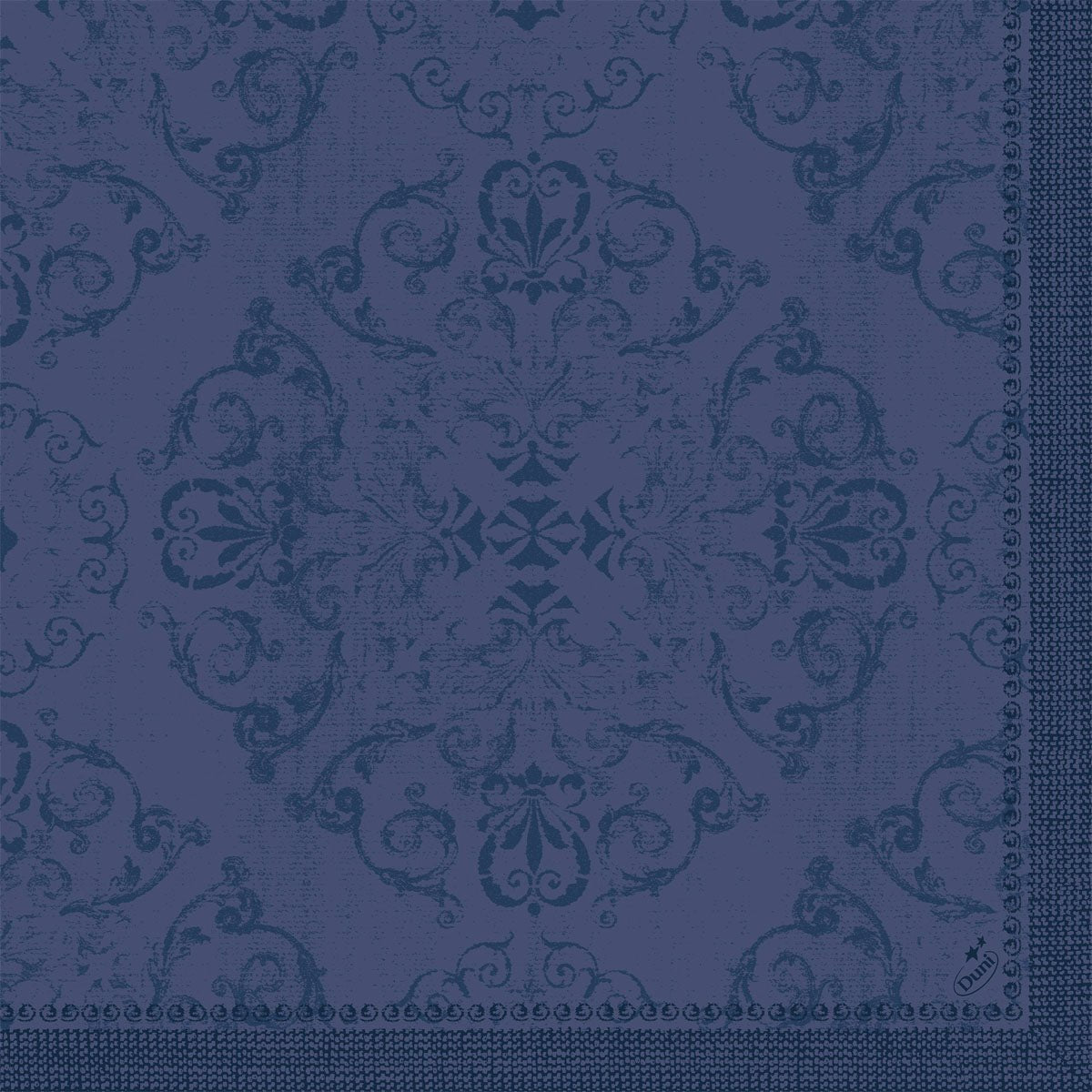 Les serviettes Dunilin 40 x 40 cm 1/4 pli de Duni GmbH avec un motif damassé bleu foncé orné de motifs floraux et de volutes ainsi qu'une bordure unie sur deux côtés offrent un aspect structuré et tissé pour une table élégamment dressée.
