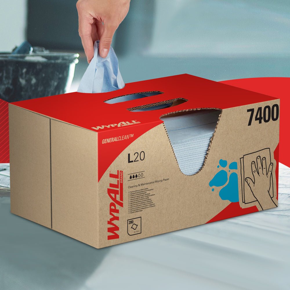 Une main tire une lingette WypAll® L20 General Clean d'une boîte bleue BRAG™ de Kimberly-Clark GmbH, qui contient 280 feuilles, et la pose sur une surface lisse.