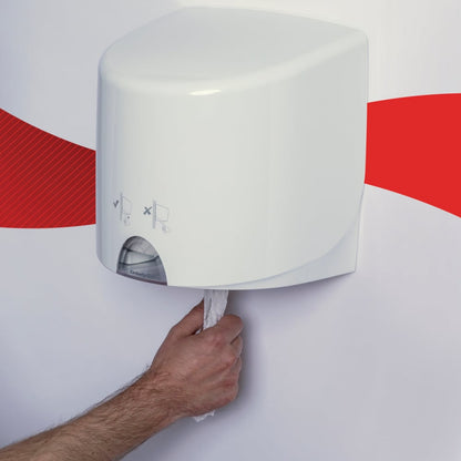 Une personne tire un papier essuie-tout WypAll® L10 de Kimberly-Clark GmbH d'un distributeur Centrefeed for Reach+™ blanc monté au mur (38,00 cm x 18,30 cm), fixé au mur avec une bande rouge.