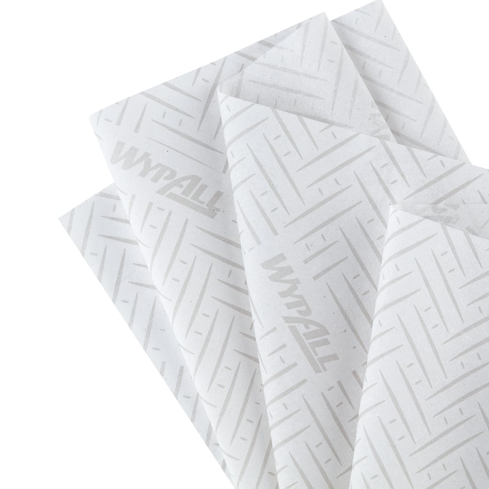 Quatre chiffons en papier WypAll® L20 superposés (38,00 x 18,30 cm) de Kimberly-Clark GmbH, blancs avec un motif discret de chevrons et de lignes et un marquage "WypAll" léger, idéaux pour les tâches de nettoyage industriel, sont éventés.