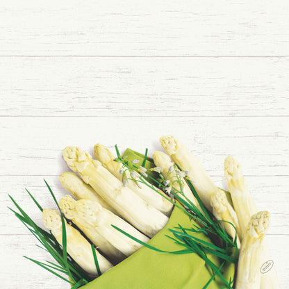 Un bouquet d'asperges blanches et d'herbes vertes repose sur une serviette Bio-Dunisoft de 40x40cm de Duni GmbH devant un fond en bois blanc.