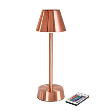La lampe LED sans fil ZELDA en or rose de Duni GmbH a un abat-jour conique, un socle cylindrique et est livrée avec une petite télécommande avec des boutons colorés.