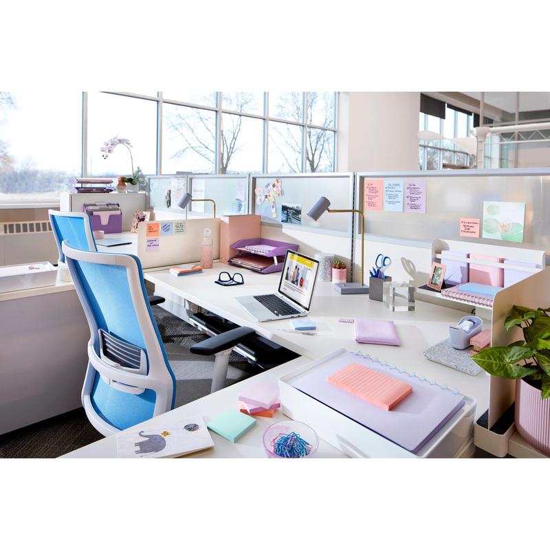 Un espace de travail de bureau moderne avec des bureaux blancs, des chaises bleues, des ordinateurs portables, des fournitures de bureau, des plantes en pot et de la lumière naturelle montre des Post-it® Super Sticky Notes (76 mm x 127 mm, 90 feuilles/bloc, 100% PEFC) de 3M Deutschland GmbH.