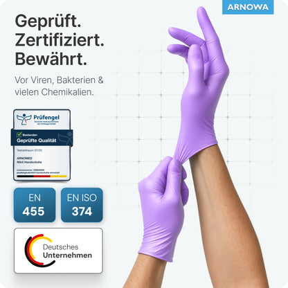 Une personne porte des gants jetables ARNOMED NITRIL LAVENDER VIOLET de ARNOWA GmbH. Les textes allemands soulignent la protection certifiée contre les virus, les bactéries et les produits chimiques. Les symboles de certification et le logo ARNOWA sont visibles. Les gants sont sans poudre.