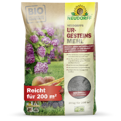 Un sac de 20 kg de farine de roche de Neudorff du magasin Neudorff, illustré avec des fleurs violettes, des carottes et des images de sol. Le sac avec l'inscription allemande couvre 200 m² et contient de la poudre minérale pour une utilisation dans le sol.