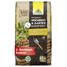 Un sac de 40 litres de NeudoHum Hochbeet- & GartenKompost de Neudorff Shop - compost biologique sans tourbe pour les plates-bandes surélevées ou les jardins, avec des légumes et une pelle sur le devant.