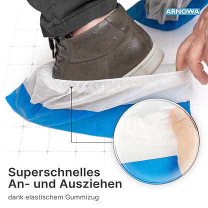 Une personne enfile un couvre-chaussures ARNOMED CPE/PP bleu-blanc, imperméable, jetable (ARNOWA GmbH) sur une chaussure marron. Une incrustation montre l'élastique pour un enfilage et un retrait faciles, comme décrit dans le texte allemand. Le sachet contient 50 pièces.