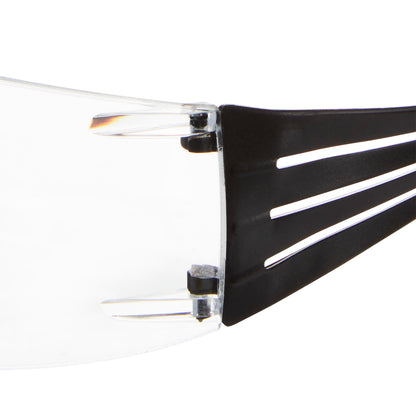 Nahaufnahme des Scharnierbereichs, in dem eine klare Kunststofflinse auf einen schwarzen Arm der 3M™ SecureFit™ Lese-Schutzbrille der 3M Deutschland GmbH trifft, mit Hervorhebung von Verbindungs- und Designdetails.