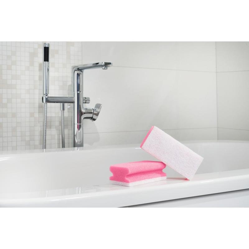 Une éponge à poignée Scotch-Brite® Bath XXL pour la salle de bain de 3M Deutschland GmbH repose sur le bord d'une baignoire blanche, prête pour le nettoyage, avec robinet chromé et mur carrelé en arrière-plan. 1 pièce par paquet.