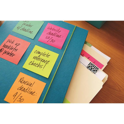 Une chemise bleue avec des cubes de notes Post-it® Ultra-Couleurs de 3M Deutschland GmbH (76x76 mm, 450 feuilles/bloc, certifié PEFC) où des tâches sont listées, repose à côté de chemises manila et d'un bloc-notes sur une table en bois.