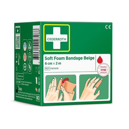 Une boîte verte portant la mention « Cederroth bande de mousse souple beige 6 cm x 2 m | Paquet (1 pièce) » de la marque Orkla Wound Care AB comporte des illustrations de pansements pour les mains, un symbole rouge en forme de goutte, des pictogrammes ainsi que les coordonnées du fabricant sur le côté.