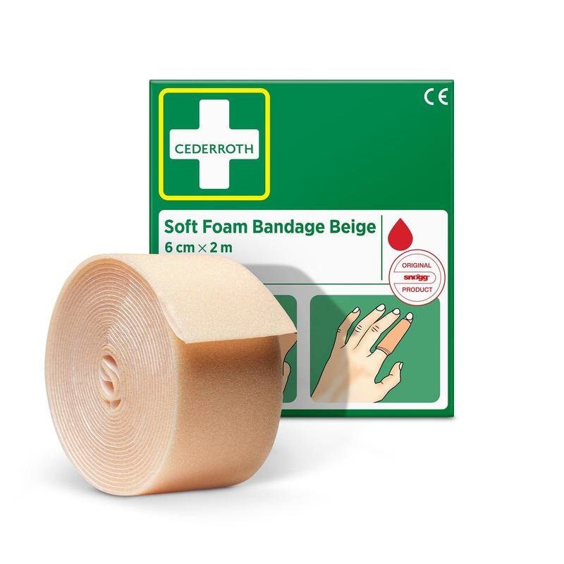 On voit un rouleau de bande de mousse souple Cederroth de couleur beige (6 cm x 2 m), fabriqué par Orkla Wound Care AB, devant son emballage vert et blanc comportant un mode d'emploi illustré et un symbole rouge en forme de goutte.