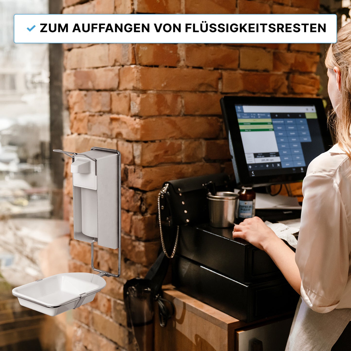 Une femme se tient à un terminal de caisse de restaurant. Sur l'image, on peut voir le BAC D'ÉGOUTTEMENT DISPENSER ARNOMED de la société ARNOWA GmbH, un bac d'égouttement pour les distributeurs de savon et de désinfectant ARNOMED, monté sur un mur en briques pour récupérer les résidus de liquide.