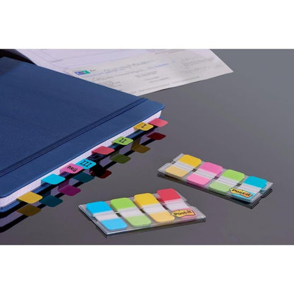 Un classeur bleu utilise les onglets de classement 3M Post-it® Index Strong (Mini, Jaune, Rouge, Bleu, Vert) pour marquer les sections I-IV. Deux paquets de bandes adhésives triées dans leurs distributeurs reposent sur une surface sombre à côté de "Organiser des documents".