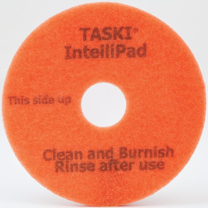 Le TASKI Intellipad, un tampon de nettoyage et de polissage combiné pour l'entretien de Diversey Deutschland GmbH & Co. OHG, est un tampon circulaire orange avec un trou au centre et l'inscription "TASKI IntelliPad", "This side up" et "Clean and Burnish, Rinse after use" en lettres grises.