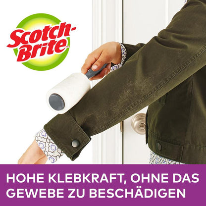 Une personne utilise un rouleau anti-peluches Scotch-Brite™ Everyday Clean, 56 feuilles, 1/paquet de 3M Deutschland GmbH sur une manche de veste vert foncé. Le texte allemand indique une forte adhérence qui enlève délicatement les peluches sans abîmer le tissu.
