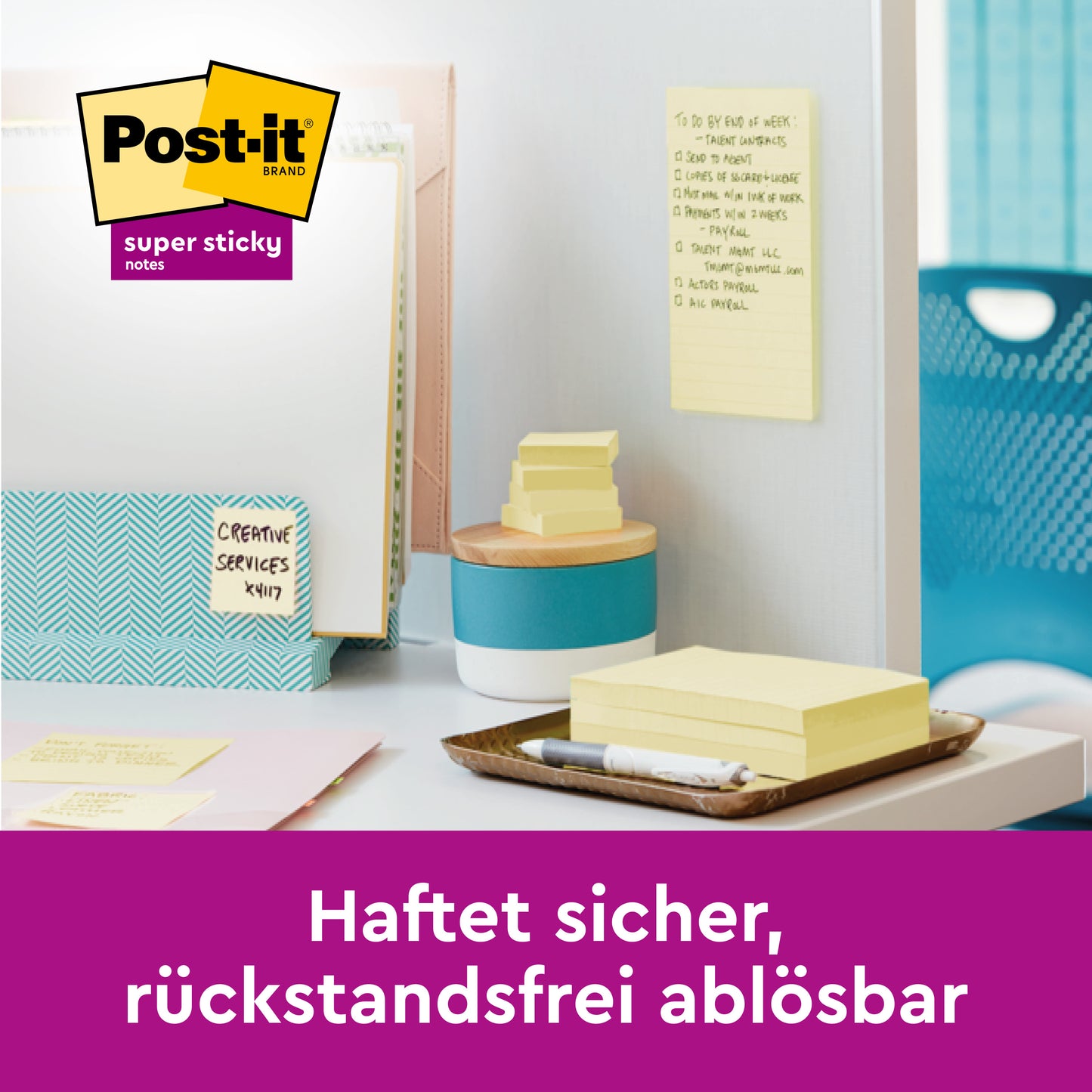 Ein Schreibtisch mit Ordnern, Stifthalter und gelben Post-it® Super Sticky Z-Notes (76 x 127 mm) von 3M Deutschland GmbH. Ein Zettel klebt an der Wand. Deutsch: "Haftet sicher, rückstandsfrei ablösbar." Packung: 12 Blöcke à 90 Blatt, Kartonverpackung.