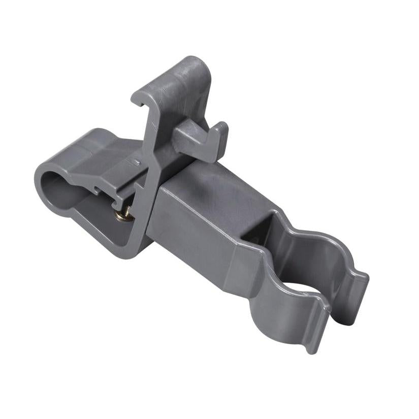 Le support d'accessoires TASKI de Diversey Deutschland GmbH & Co. OHG est une pince grise en plastique avec deux ouvertures rondes et une charnière de verrouillage. Il sert à fixer en toute sécurité des outils de nettoyage cylindriques et à organiser les accessoires de nettoyage. Surface lisse, détails inclinés.