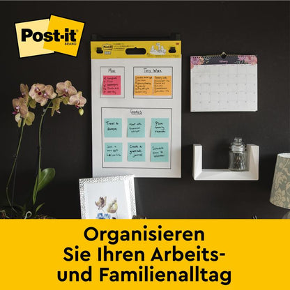 Un mur de bureau avec le tableau de réunion auto-adhésif Post-it® Super Sticky/flipchart 559 de 3M Deutschland GmbH (63,5 x 76,2 cm), calendrier mensuel, étagère avec verre, orchidée et photos. Texte : "Organisez votre quotidien.