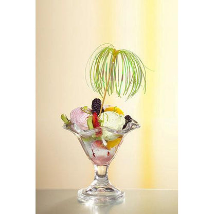 Un bol à dessert en verre avec de la glace, divers fruits et baies est garni d'un pique de décoration PAPSTAR 100 de PAPSTAR GmbH et se tient devant un fond doucement éclairé en jaune – parfait pour des présentations élégantes.