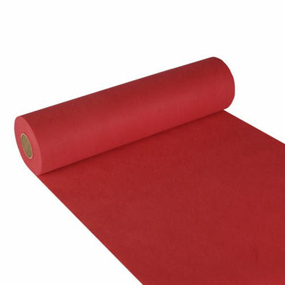 Un rouleau de chemin de table Starpak, non-tissé semblable à du tissu « Soft Selection » (24 m x 40 cm), est partiellement déroulé sur une surface blanche, le rouleau est à gauche et le chemin rouge s'étend jusqu'à l'angle inférieur droit.