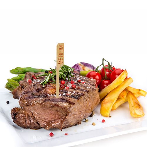 Un steak grillé avec la désignation « medium » et le PAPSTAR 250 marqueur de steak de 9 cm de la PAPSTAR GmbH est servi sur une assiette blanche avec des frites, des asperges, des tomates cerises, des oignons rouges et des herbes - parfait pour la cuisine professionnelle de restaurant.