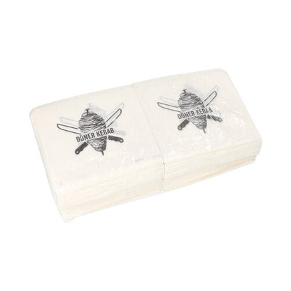 Une pile de PAPSTAR sacs à döner kebab (16x16 cm, résistant à la graisse), chacun avec une broche à döner et des couteaux croisés comme sur les serviettes, emballés dans un film rétractable (1000 pièces) de PAPSTAR GmbH.