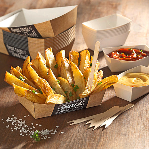 Dick geschnittene Kartoffelecken mit Petersilie werden in einer PAPSTAR 50 Pommes-Frites-Schalen „pure“ „Good Food“ (3,5 x 7 cm) der PAPSTAR GmbH auf einem Holztisch serviert, mit Soßen und Holzgabeln für ein umweltfreundliches Esserlebnis.