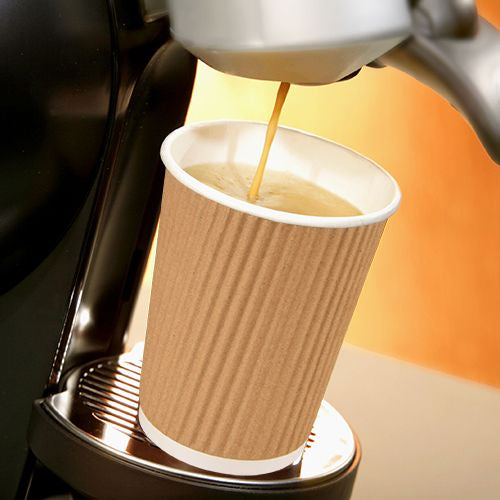 Ein PAPSTAR 10 Trinkbecher, Pappe 0,4l Ripple Wall von der PAPSTAR GmbH wird unter den Auslauf einer Kaffeemaschine gestellt, während frischer Kaffee einfließt, und hebt seine gerippte Hülle vor einem warmen Hintergrund hervor.